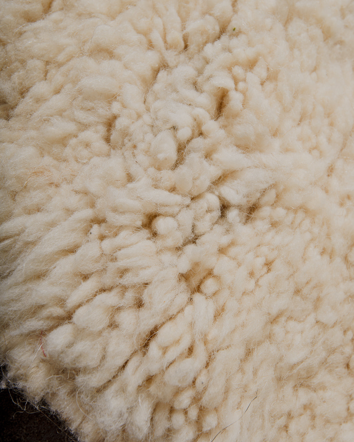 Close-up of cream wool rug showing very subtle darker area.